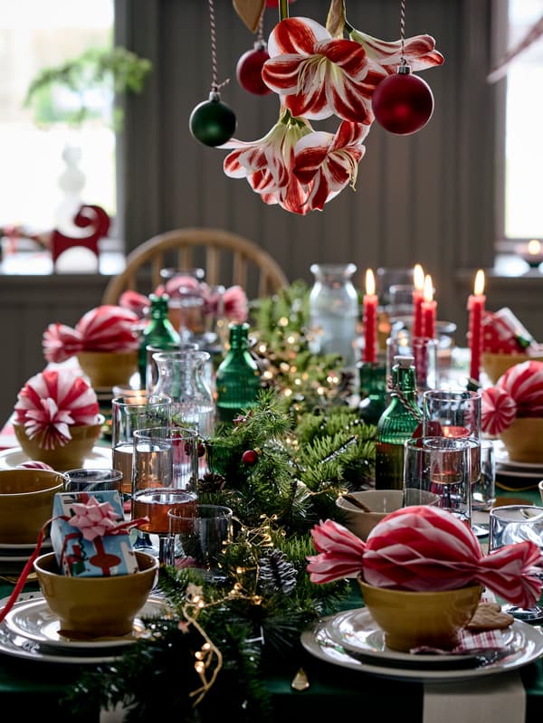 Vianočne prestretý stôl so žltými miskami SANDSKÄDDA a dekoráciami VINTERFINT.