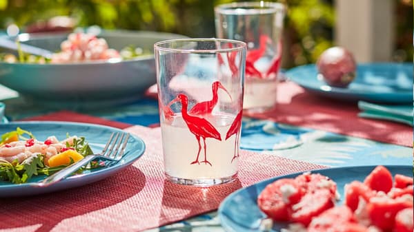 Vibráló színekben pompázó, egzotikus mintákkal díszített kiegészítőkkel terített asztal.