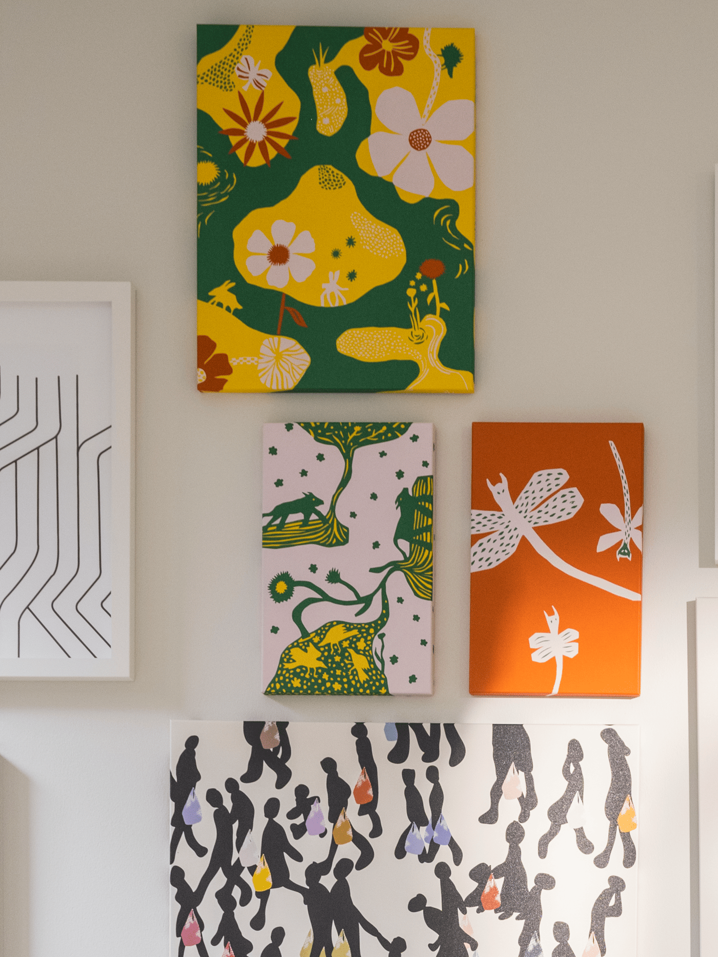 Vibrant mix of floral and abstract canvas art on a neutral wall