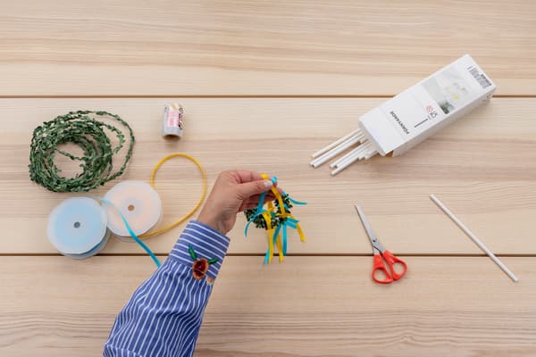 Viele Bänder sind um den kleinen Kranz befestigt.