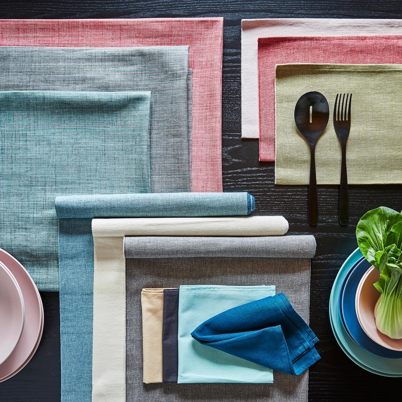 Viele verschieden farbige Tischläufer übereinander drapiert.