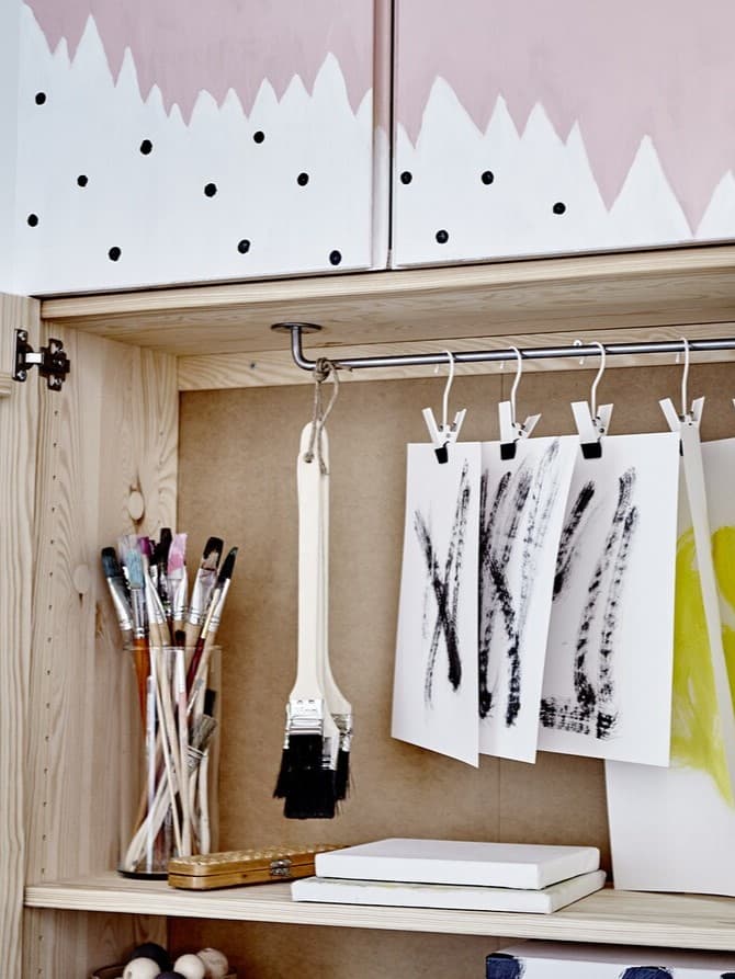 Vier IVAR Schränke, in einem abstrakten Muster bemalt, sodass ein Gesamtbild entsteht und zwar ein Gesamtbild mit viel Aufbewahrung dahinter.