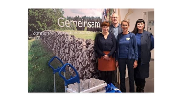 Vier Personen stehen vor einem Plakat bei IKEA.