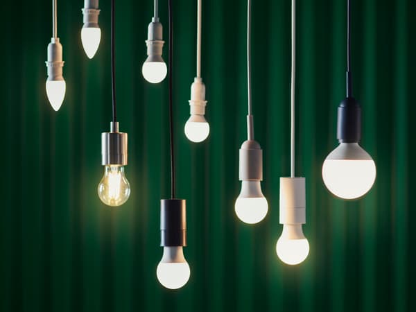 Világító LED izzók lógnak zöld háttér előtt.
