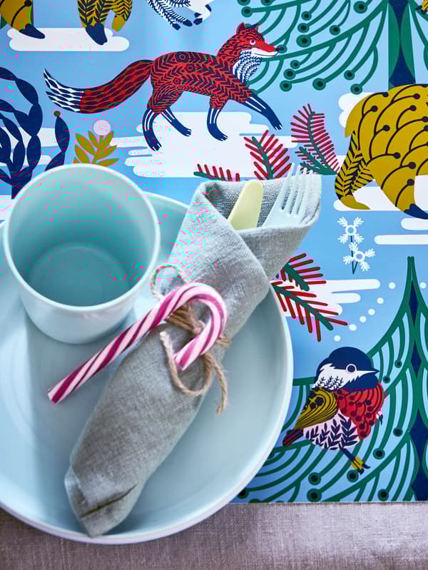 Világoskék KALAS tál és pohár, alattuk VINTERFINT tányéralátét.