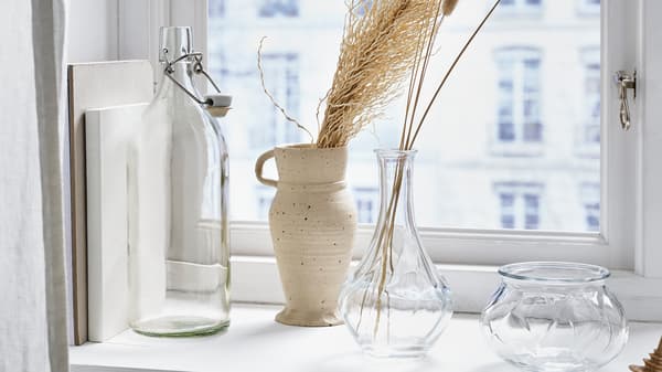 VILJESTARK vases on a window ledgfe beside a KORKEN jar.