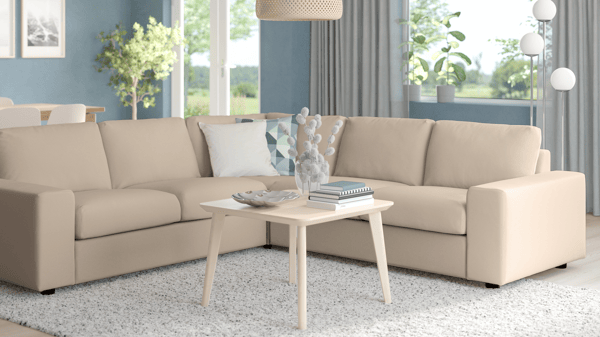 VIMLE modular sofa in beige with L-shaped layout, placed in a bright living room with light blue curtains and white coffee table.