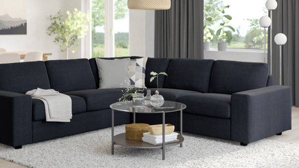 VIMLE modular sofa in black with L-shaped setup, styled in a modern room with dark curtains and round glass coffee table.