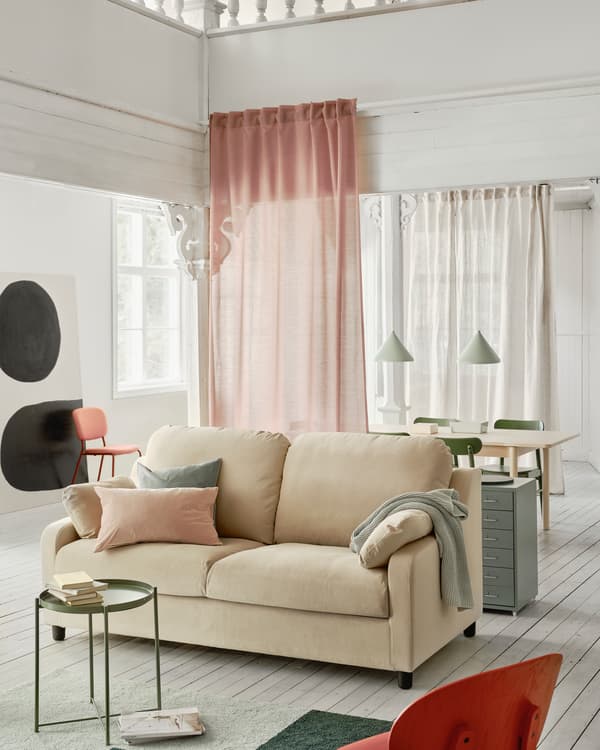 VINLIDEN sofa in beige with generous dimensions standing in a living room with a rug and small table in the foreground.