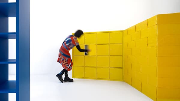 Visitor peeks into larger-than-life KALLAX installation at Mason Studio.