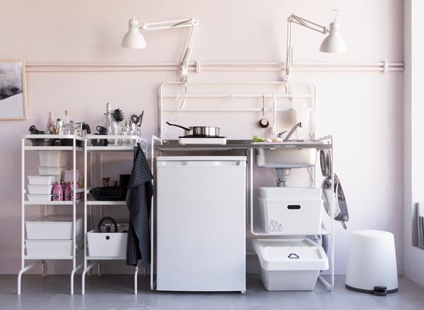 Vista completa dunha minicociña IKEA SUNNERSTA en aceiro inoxidable branco que inclúe andeis para clasificar residuos.