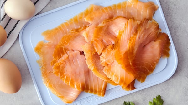 Vista dall'alto di fettine di salmone affumicato servite su di un vassoio.