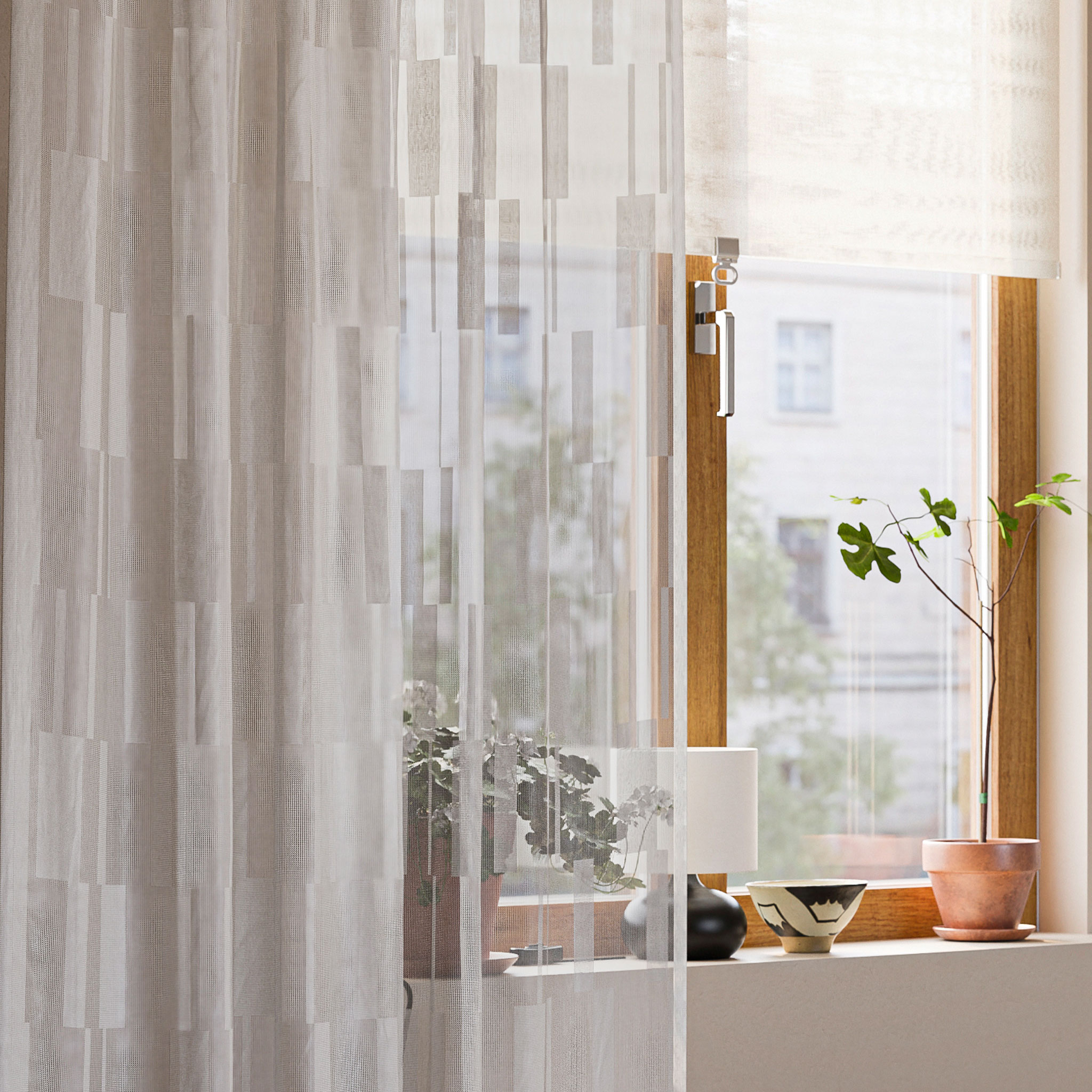 Vit skir gardin i fönster med lampa och växter.