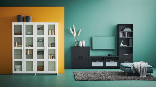 Vitrine blanche avec de la décoration à l'intérieur et meuble de télé noir.