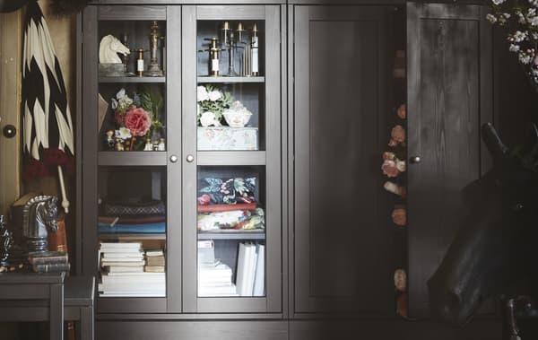 Vitrine HAVSTA avec fleurs, livres et bougeoirs.