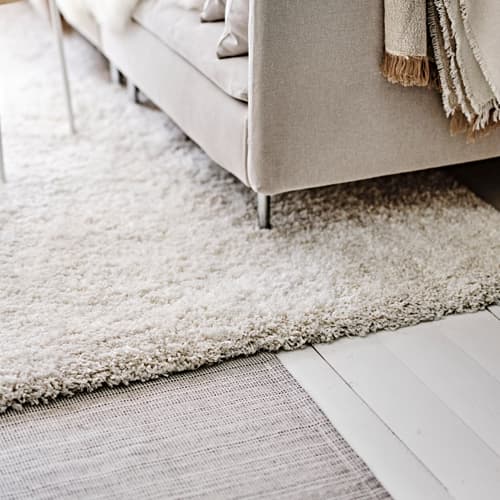 Vloerkleed waar deels een bank op staat.