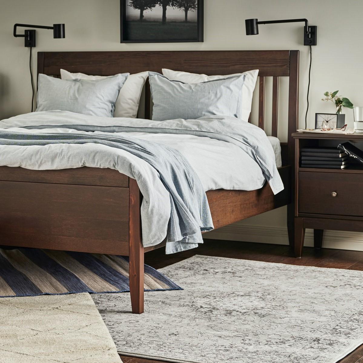 Vložnice v které je umístěná manželská postel a kolem ní je koberec a noční stolek.