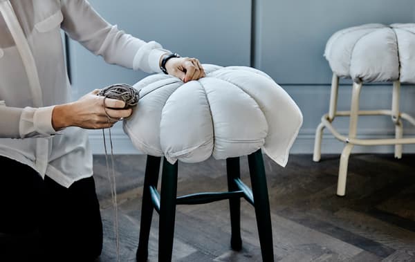 Voici une idée créative qui ne prend pas plus de 5 minutes et rend confortables des sièges inconfortables. Il vous faut juste un oreiller et de la ficelle (rustique, par exemple). Fixez le coussin au tabouret en enroulant la ficelle autour de manière à réaliser 8 sections égales et faites un nœud serré sur le dessus. Et voilà!
