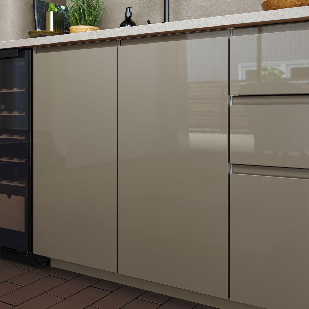 VOXTORP højglans gråbrun køkkenlåger.
Flere gråbrune køkkenskabe og et køkkenskab med skuffer står ved siden af hinanden. De gråbrune køkkenskabe har VOXTORP låger og skuffefronter i gråbrun højglans med integrerede greb og en hvid bordplade. På bordpladen står en tekoger, en potteplante og andre køkkenting.