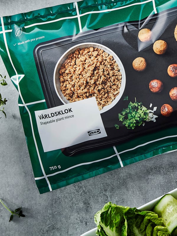 Vrecko s bezmäsitou zmesou VÄRLDSKLOK je na stole vedľa taniera so šalátom.