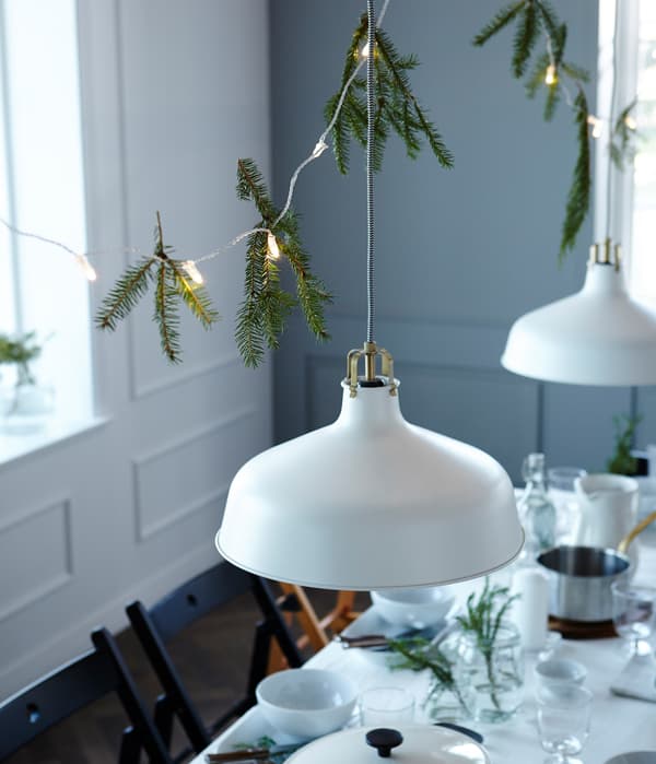 Vrei să îţi impresionezi invitaţii? Agaţă decoraţiuni deasupra mesei! Noi am folosit ghirlande luminoase şi crengi de brad.nches.