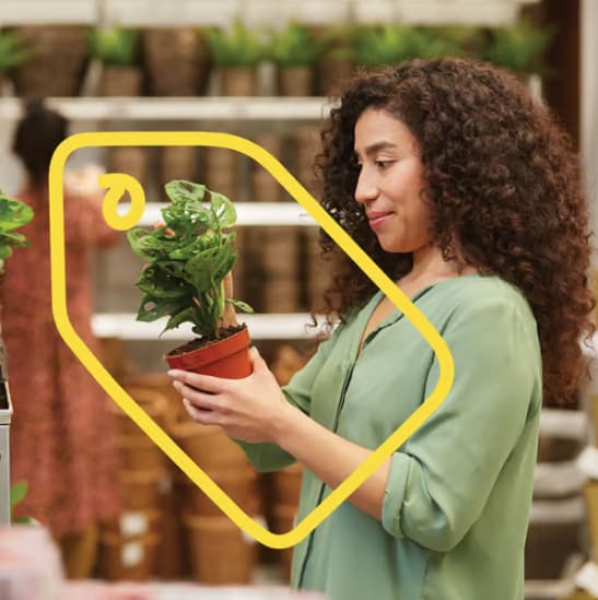 Vrouw die blij kijkt naar een plant