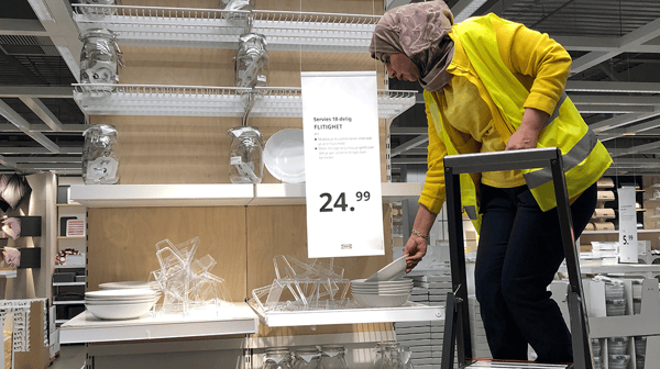 Vrouw die spullen aan het organiseren is op een plank in een IKEA.