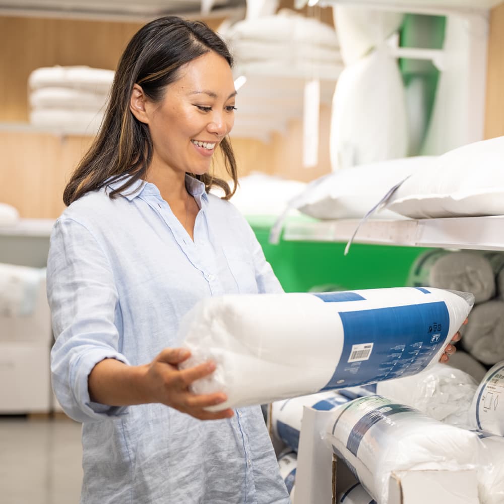 Vrouw met hoofdkussen in verpakking in haar handen
