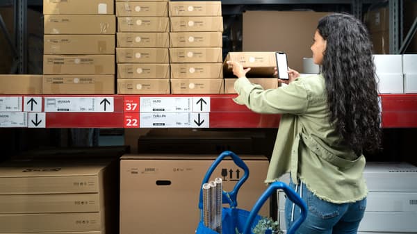 Vrouw scant de streepjescode van een platte verpakking van een IKEA product.