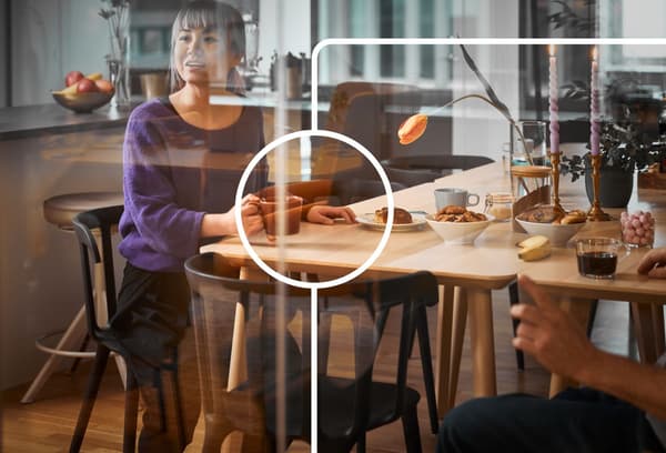 Vrouw zit rond een tafel en drinkt koffie.