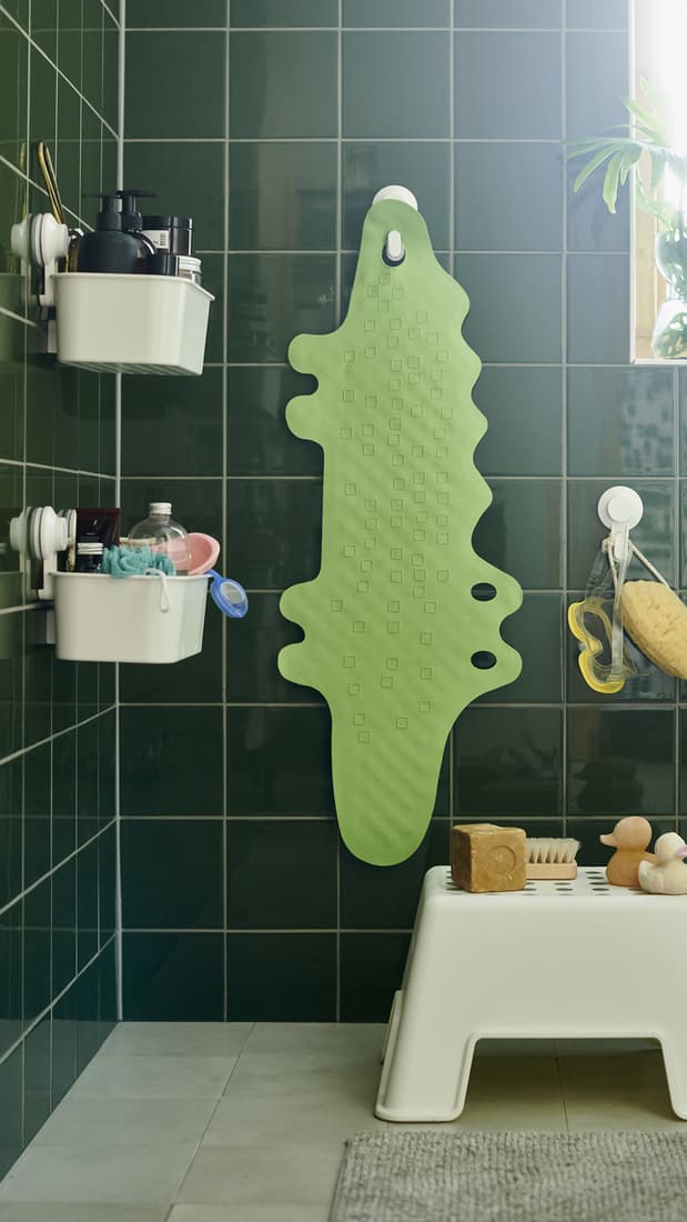 Vsita de un baño con organizadores de ducha con ventosas que contienen una serie de objetos en su interior. 