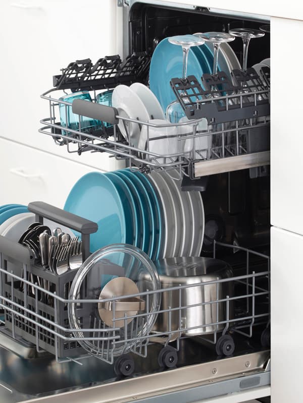 Vstavaná umývačka riadu s otvorenými dvierkami a vysunutými košmi plnými umytého riadu v bielej kuchynskej zostave.
