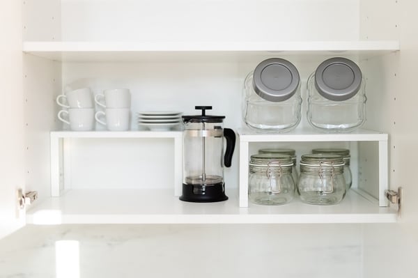 Выдвижной кухонный ящик с бамбуковыми органайзерами и баночками для специй рядом со встроенной духовкой
