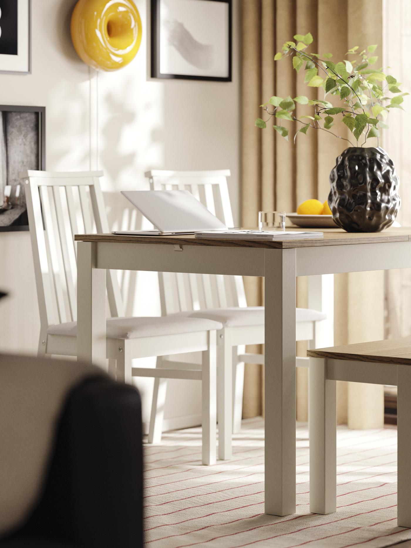 W jadalni znajduje się beżowo-brązowy rozkładany stół ÅLHULT z ławką po jednej stronie i dwoma krzesłami z miękkimi siedziskami po drugiej.
