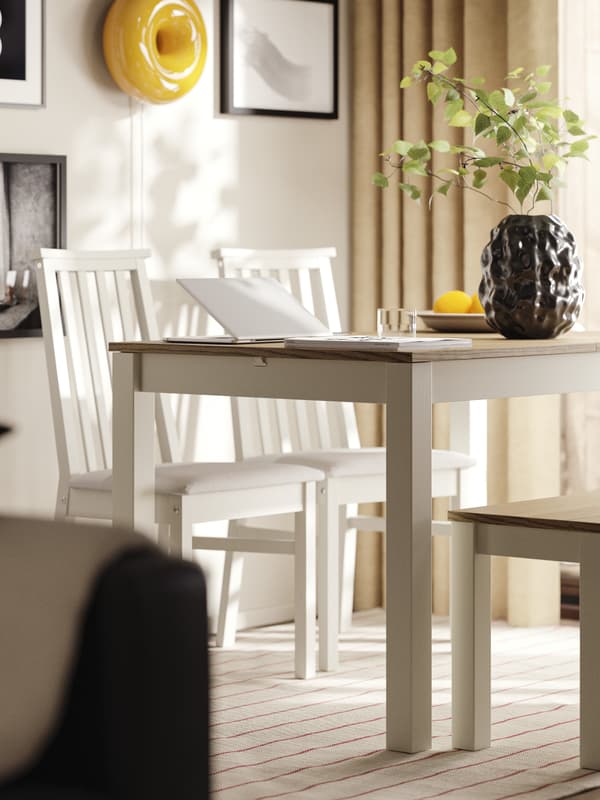 W jadalni znajduje się beżowo-brązowy rozkładany stół ÅLHULT z ławką po jednej stronie i dwoma krzesłami z miękkimi siedziskami po drugiej.