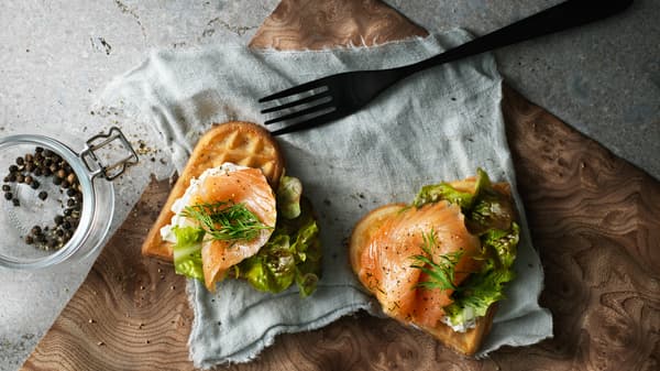 ワッフルの上にサーモンとチーズと野菜が載っている様子