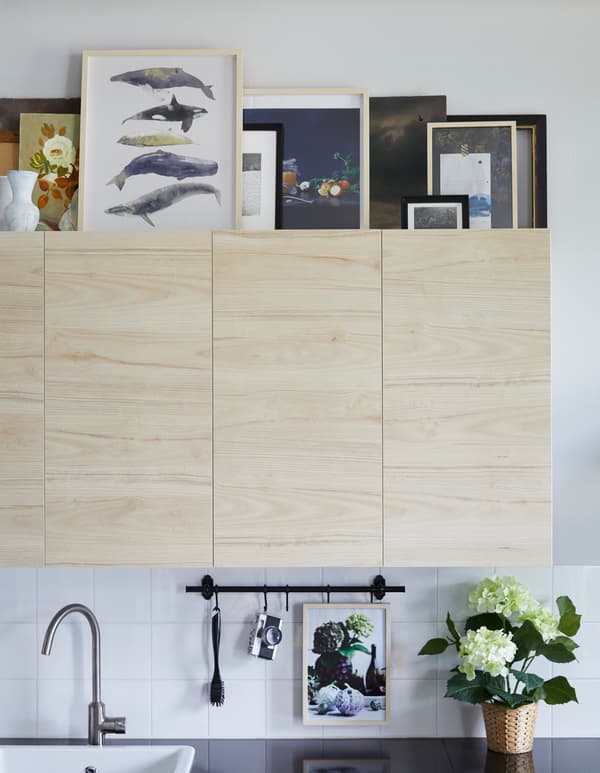 Want art for your kitchen? IKEA has lots to choose from, especially pieces easy to see at a distance for those spots above kitchen cabinets. For a calm look, choose one or two frame styles like modern HOVSTA frame in birch.