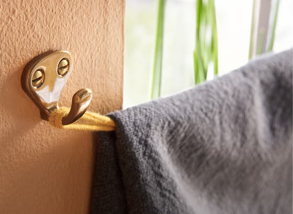 Want both privacy and some daylight? Fold a throw over a horizontal fabric ribbon that you attach to hooks. IKEA offers a wide range of smart hooks such as IKEA KVASP hook in brass-colour.