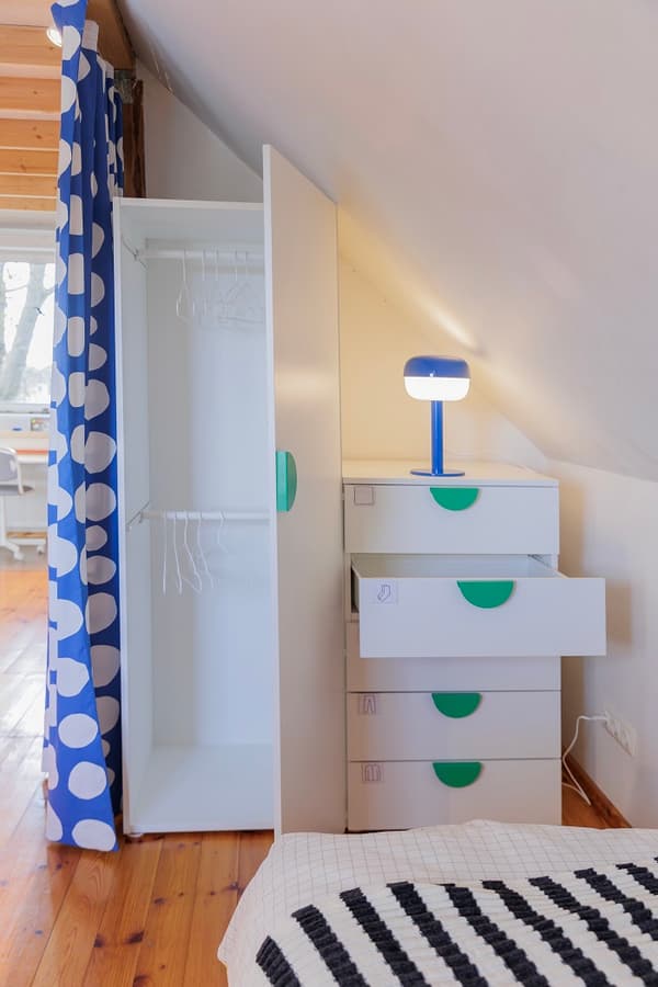 Wardrobe cabinet with open door and drawers in kids room