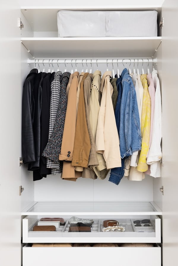Wardrobe interior with hanging rails, shelves and drawers for organised storage.