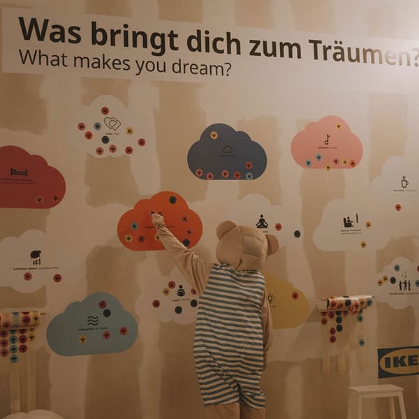 Was bringt dich zum Träumen? Wandbemaling mit Wolken un einem Täddibar der eine Wolke greift