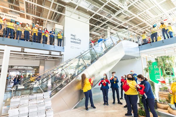Wejście do sklepu IKEA Szczecin, przed schodami na 1. piętro. Na parterze i na 1 piętrze stoją pracownicy z sercami-maskotkami i falagami Polski i Szwecji.