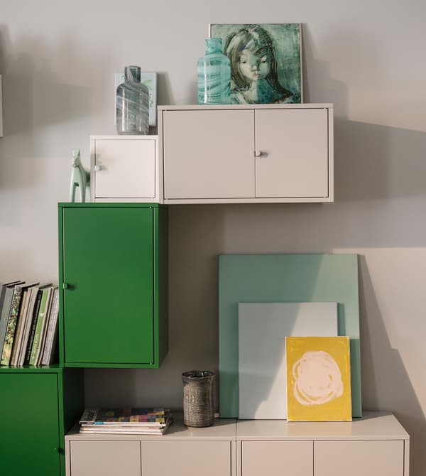White and green cabinets and artwork decorate the walls.