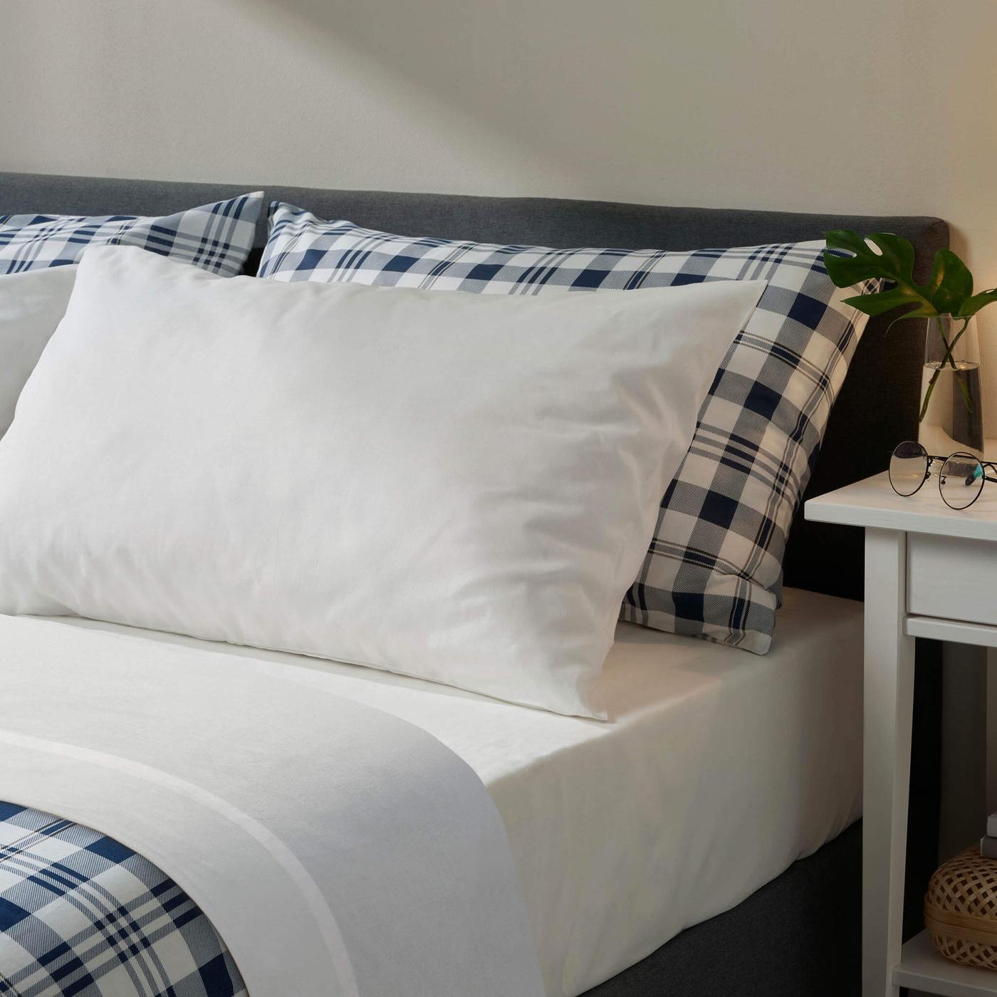 White bed sheets on a bed.