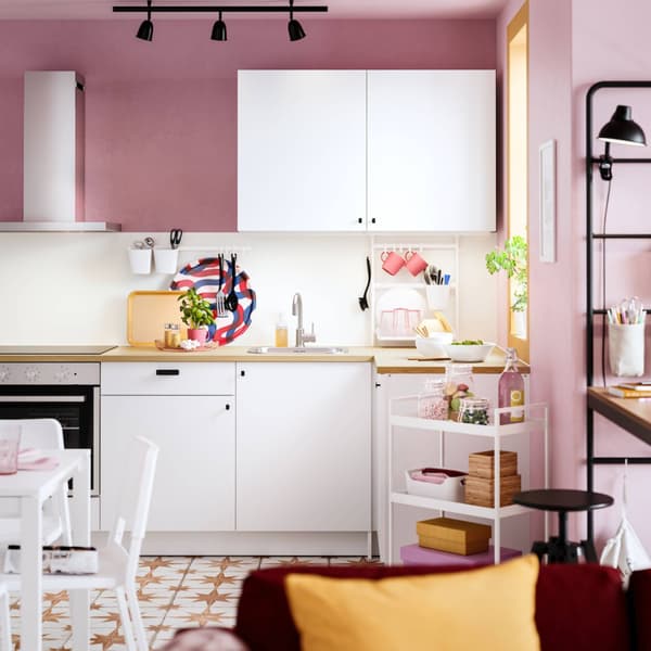 White KNOXHULT kitchen , top hung and bottom cabinets in a pink room.