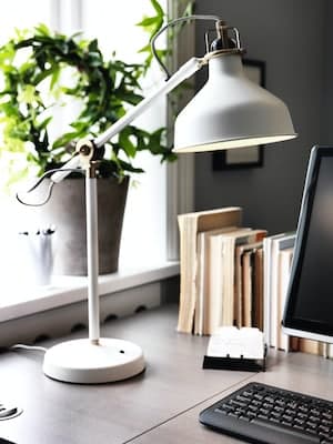 White lamp placed on top of a desk 