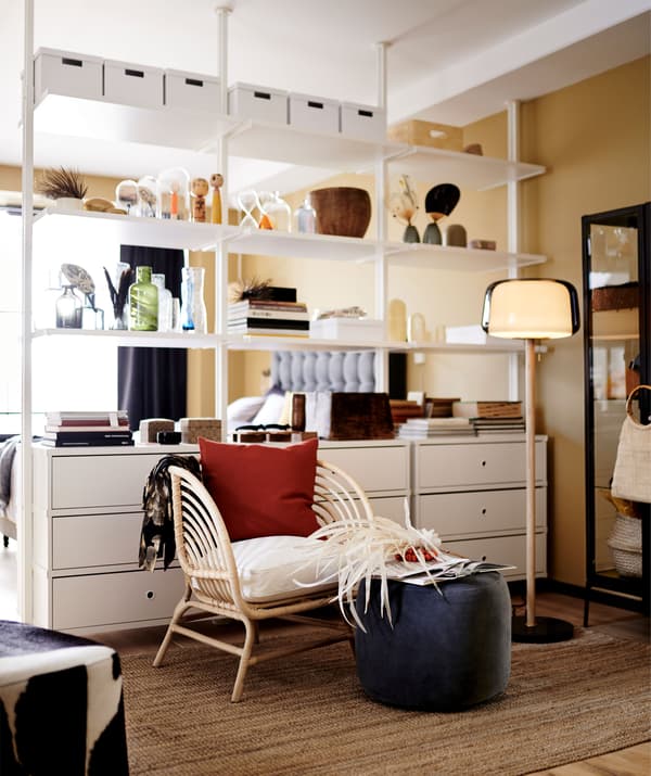 White modular ELVARLI storage unit used as a room divider in an open-plan living room.