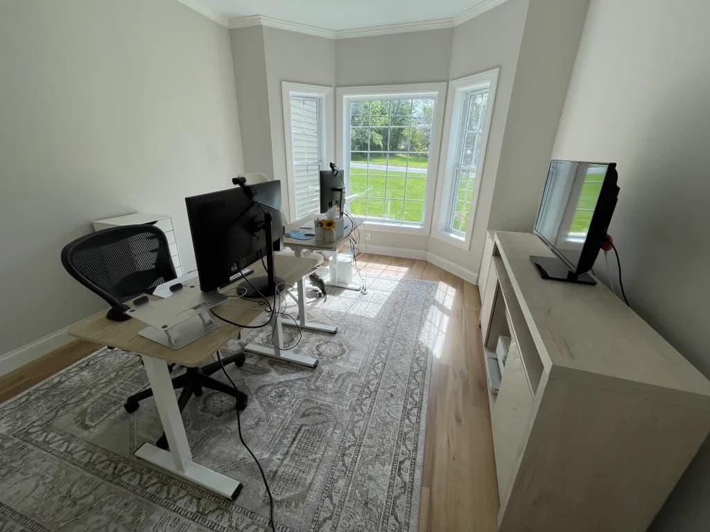 White office room with desk and monitors.