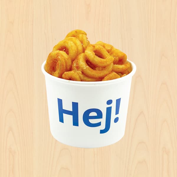White paper cup labeled “Hej!” overflowing with golden curly fries, centered on a light wood background; bright, appetizing fast-food presentation.