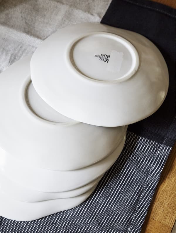 White plates stacked on a tea towel.